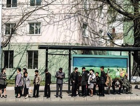 مسافران در ایستگاه اتوبوس شهر پیونگ‌یانگ منتظر اتوبوس هستند