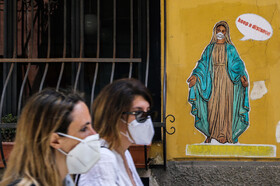 نقاشی دیواری از شخصیتی مقدس با ماسک بر صورت در مرکز ناپلی، ایتالیا