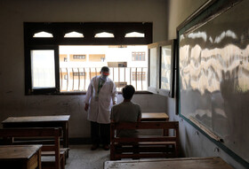 پزشک مشغول معاینه دانش آموز در روز امتحان در قاهره مصر